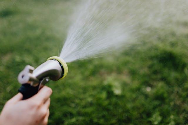 close up of hand holding water sprinkler